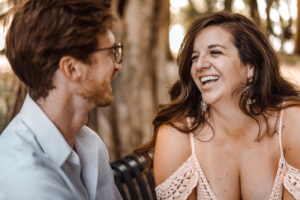 Elopement Photographer, a man and a woman sit on park bench and laugh as they talk together